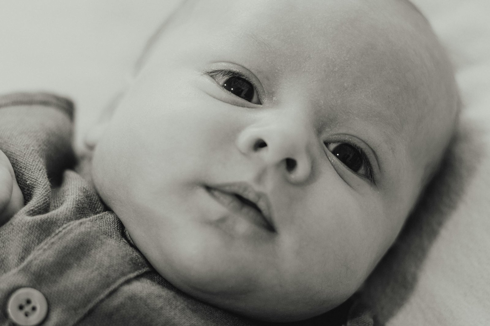 Heartwarming close-up portrait of a newborn baby in black and white, showcasing innocence and purity.